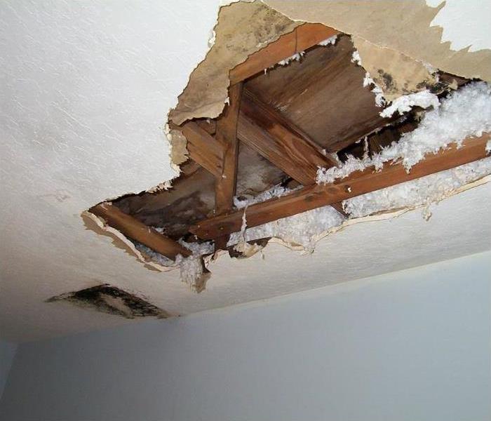 Image of hole in ceiling caused by water damage.